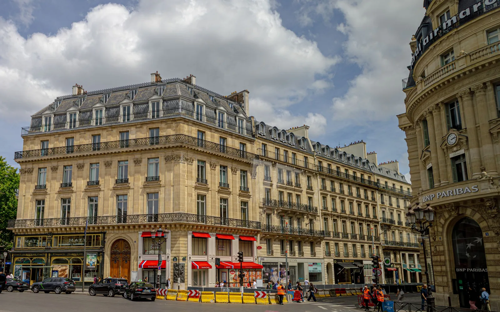 Photographie d'une conseillère bancaire présentant une brochure santé à un client dans une agence BNP Paribas.
